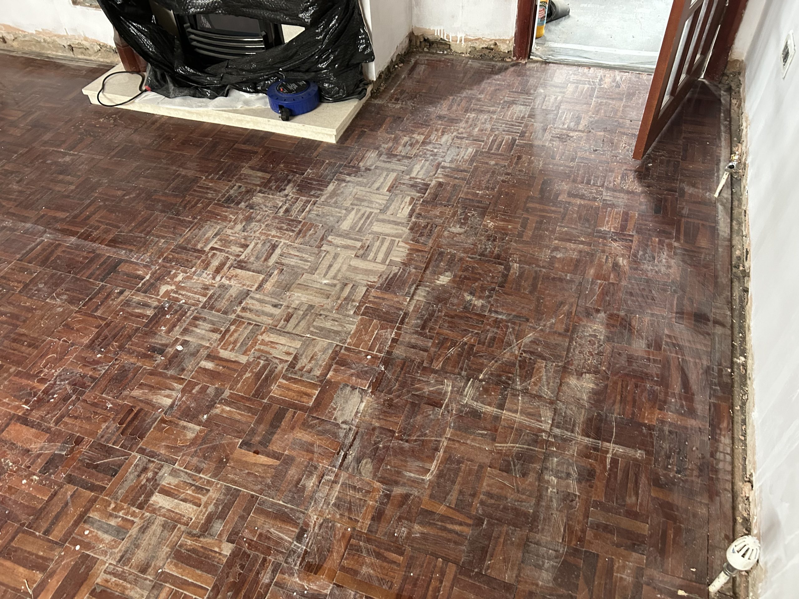 Wood Floor Sanding in New Southgate on a worn hardwood block parquet floor, showing heavy scratches and old finish before restoration.